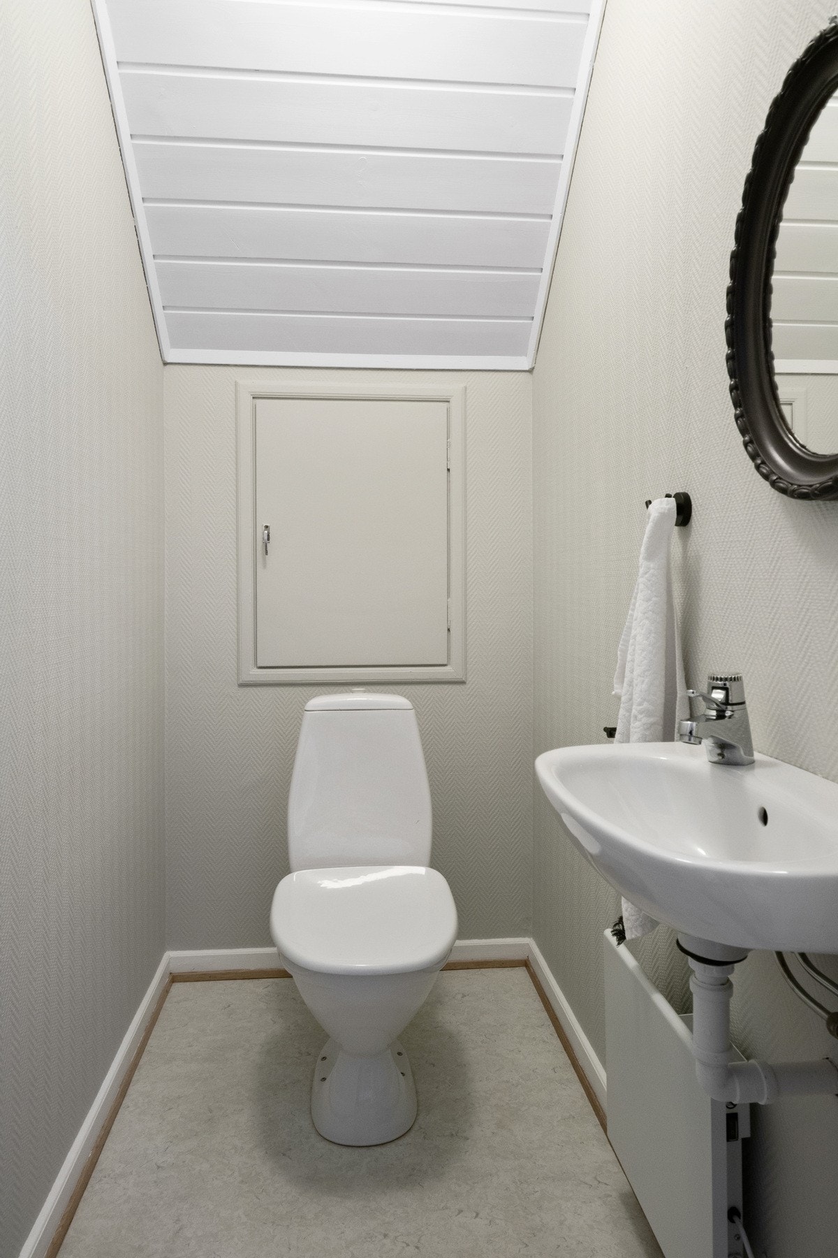 I direkte tilknytning ligger et separat wc-rom, innredet med toalett, en enkel servant og rundt speil med belysning. Galleribilde