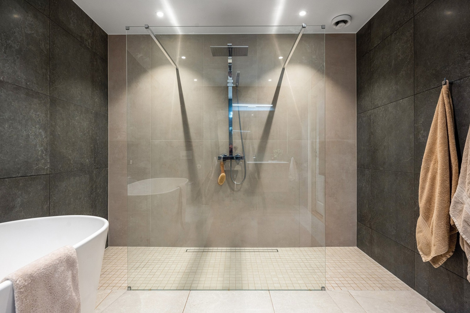 Badet er innredet med frittstående badekar og dusj med glassvegg. Galleribilde