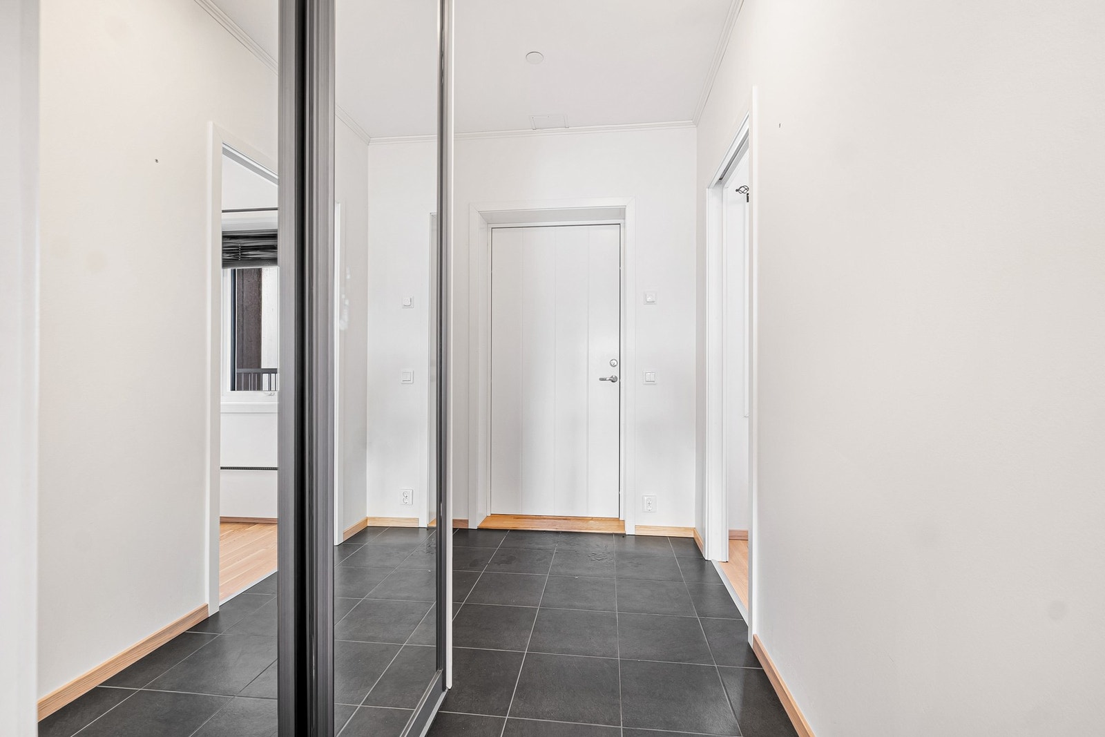 Praktisk gang med elektriske varmekabler i gulv og skyvedørsgarderobe Galleribilde