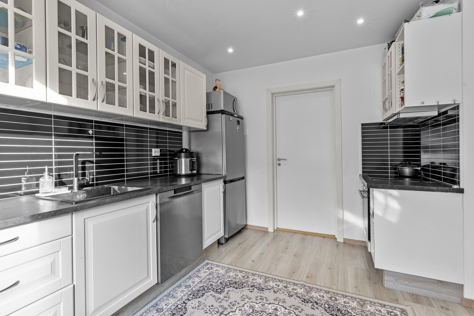 Kjøkkenet har godt med skap- og benkeplass, samt moderne overflater Galleribilde