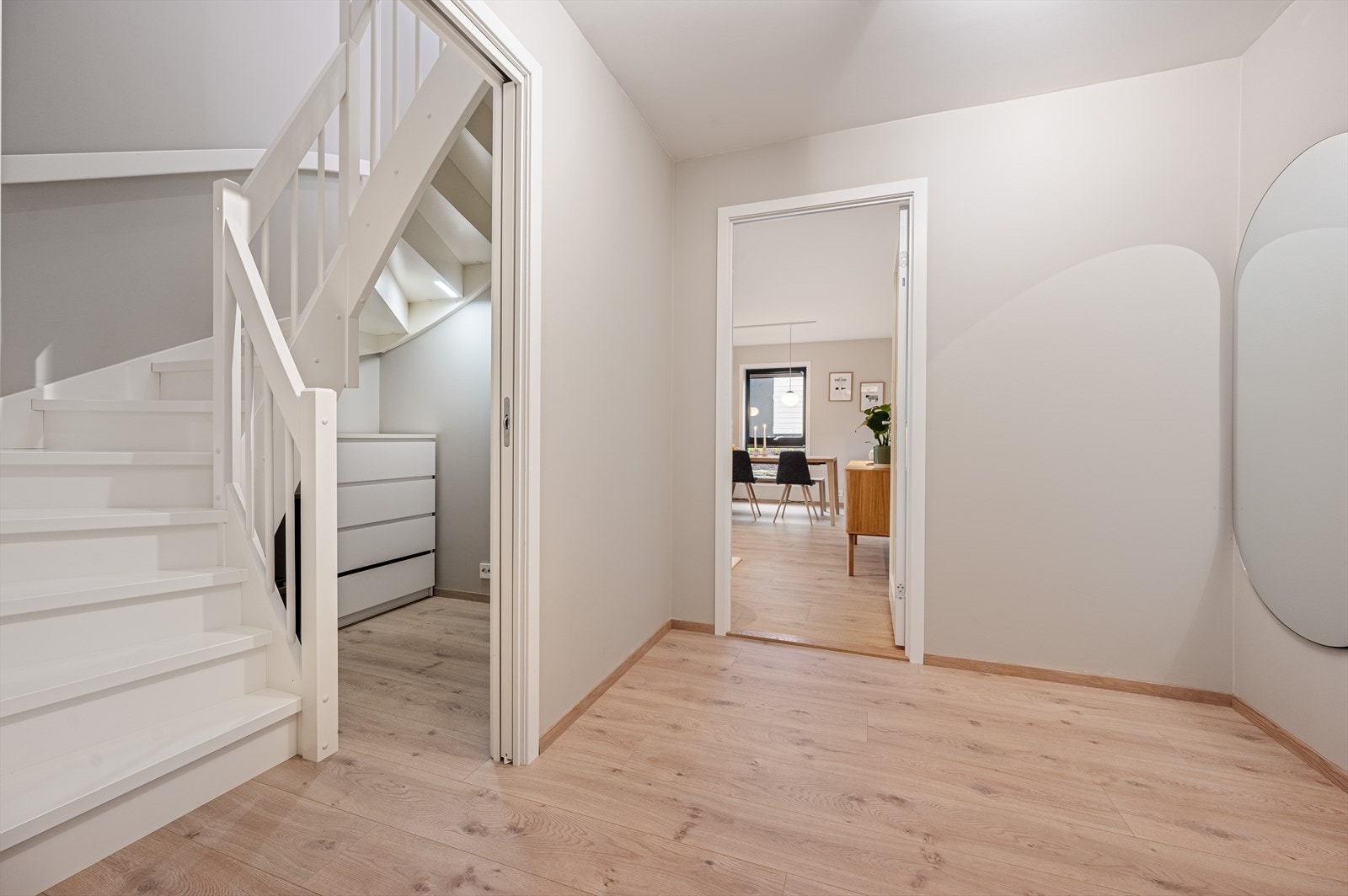 Innbydende entré med laminatgulv og malt tretrapp til andre etasje. Galleribilde