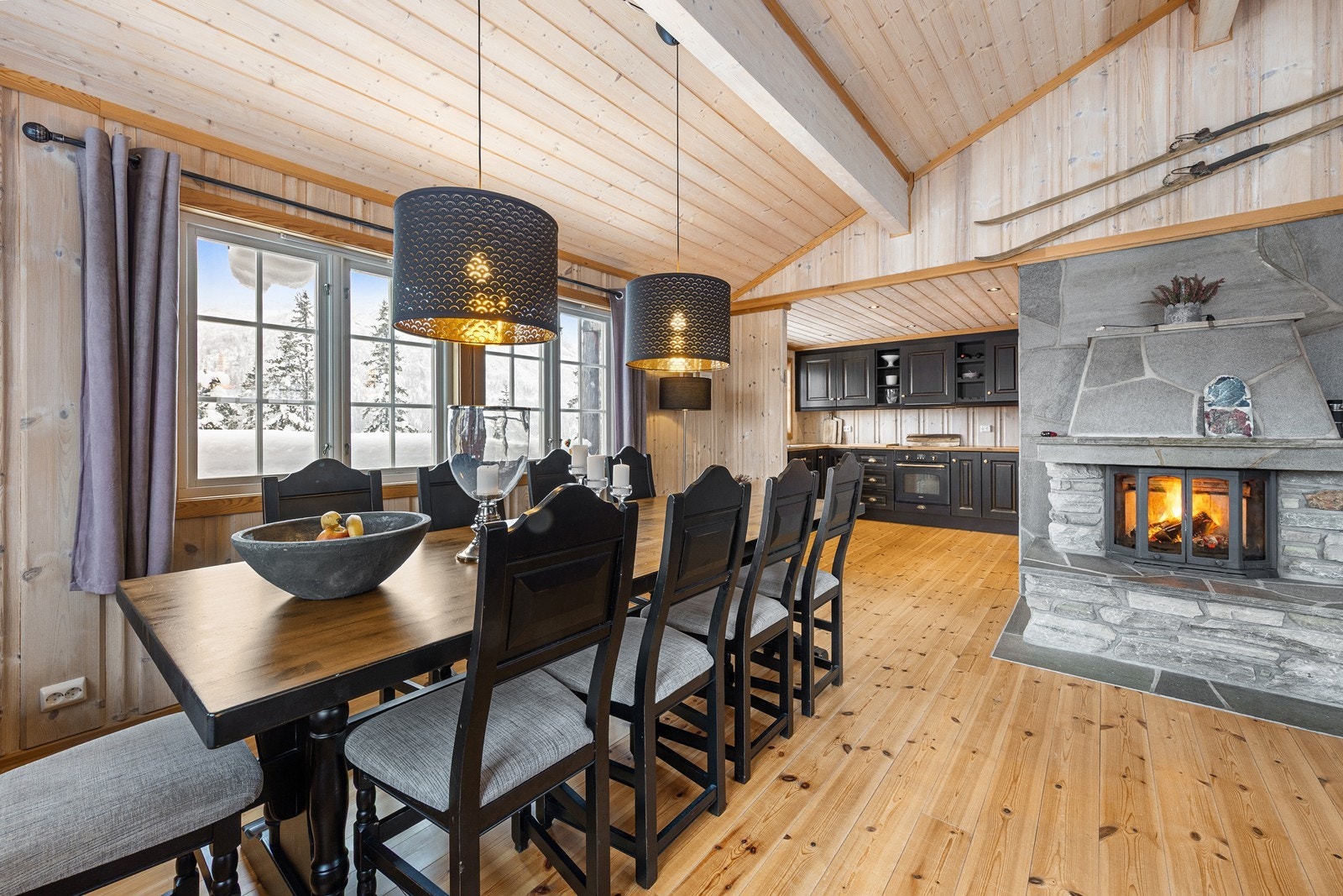 Delvis åpen løsning mot kjøkken, og pen peisovn med innsats. Galleribilde