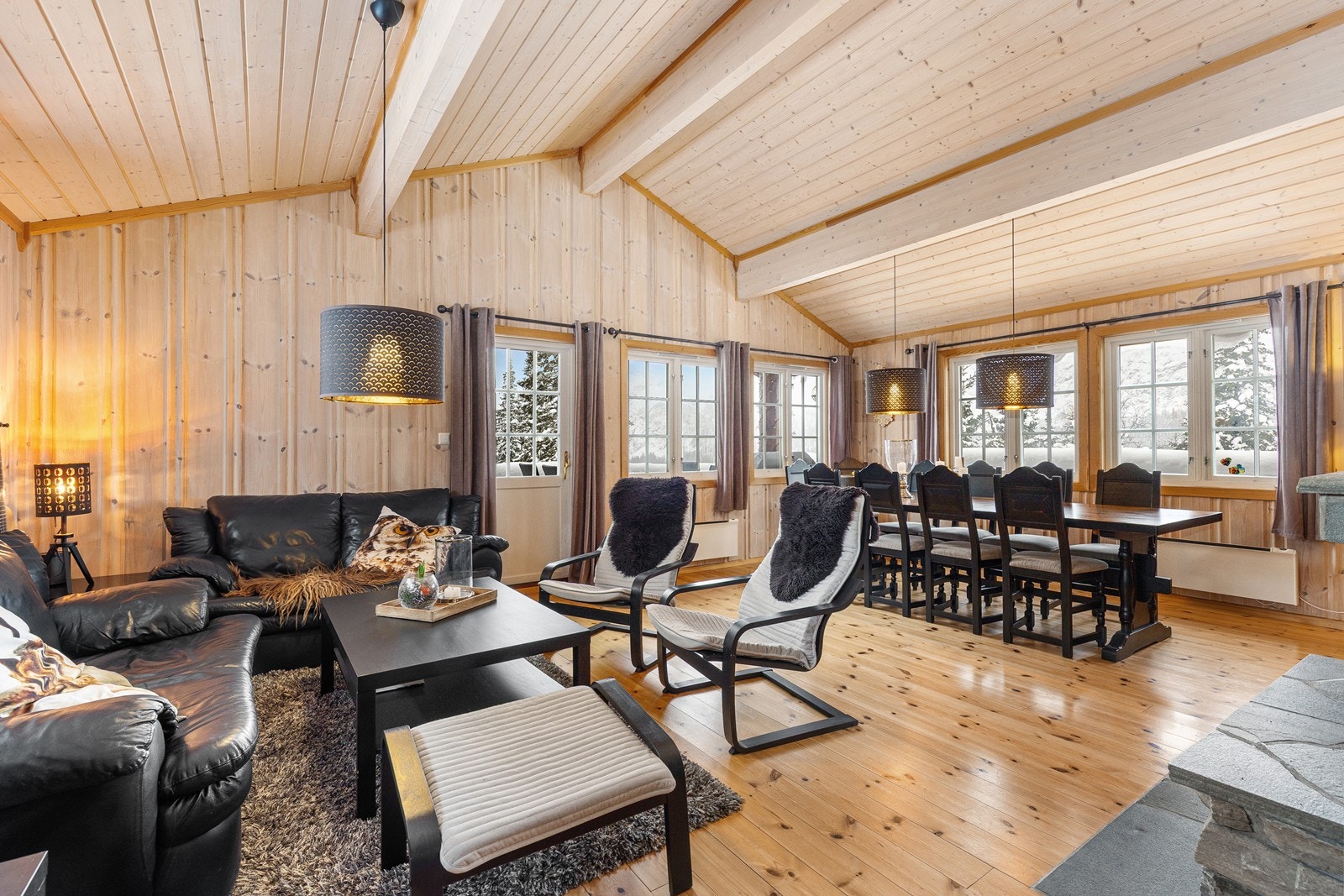 Store vindusflater gir mye naturlig lys inn i stuen. Stuen er romslig, og har god plass til møblement. Galleribilde