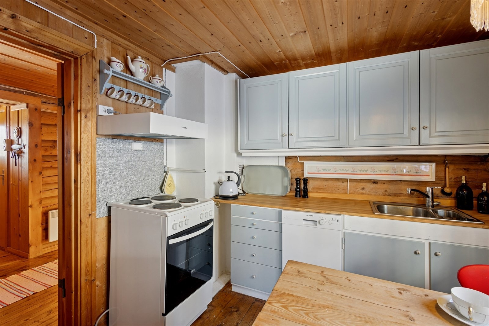 Kjøkkenet har en innredning med laminerte skrog, profilerte fronter og en benkeplate i heltre med nedfelt kjøkkenkum. Galleribilde