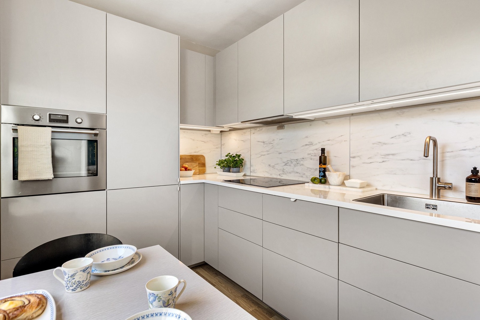 Kjøkkenet er utstyrt med glatte fronter, slitesterk benkeplate med nedfelt stålkum og praktiske kitchen boards over benk. Galleribilde