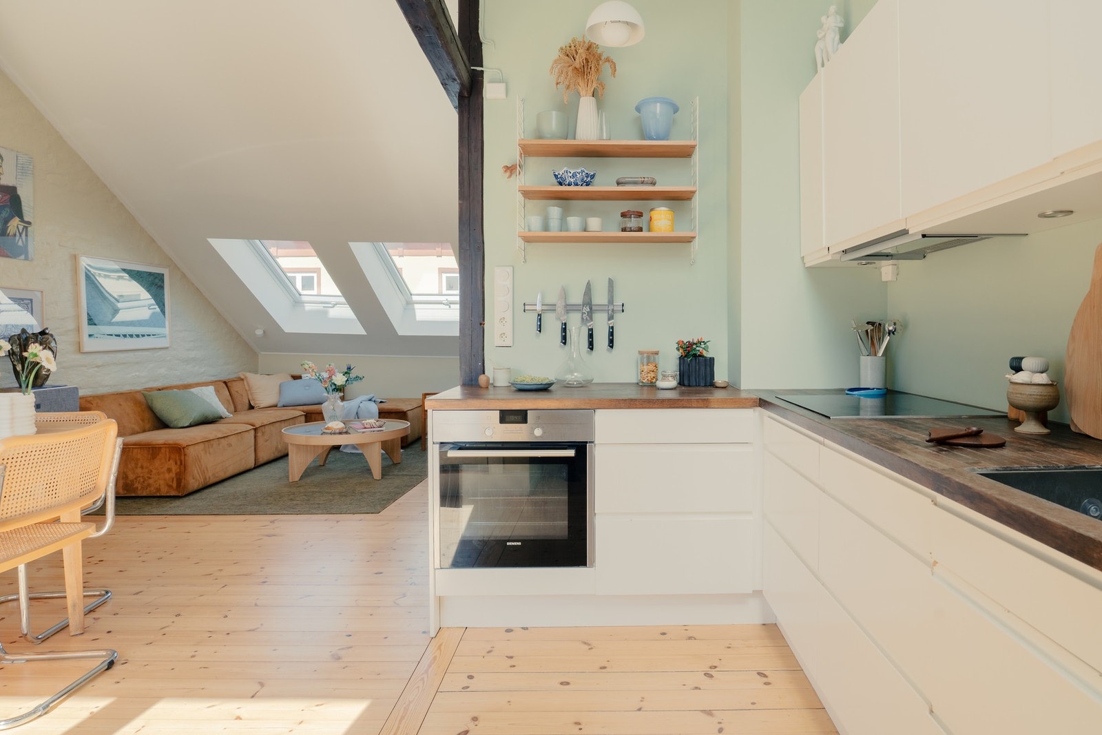 Lys og funksjonell kjøkkenløsning som er del av boligens gjennomgående planløsning. Galleribilde