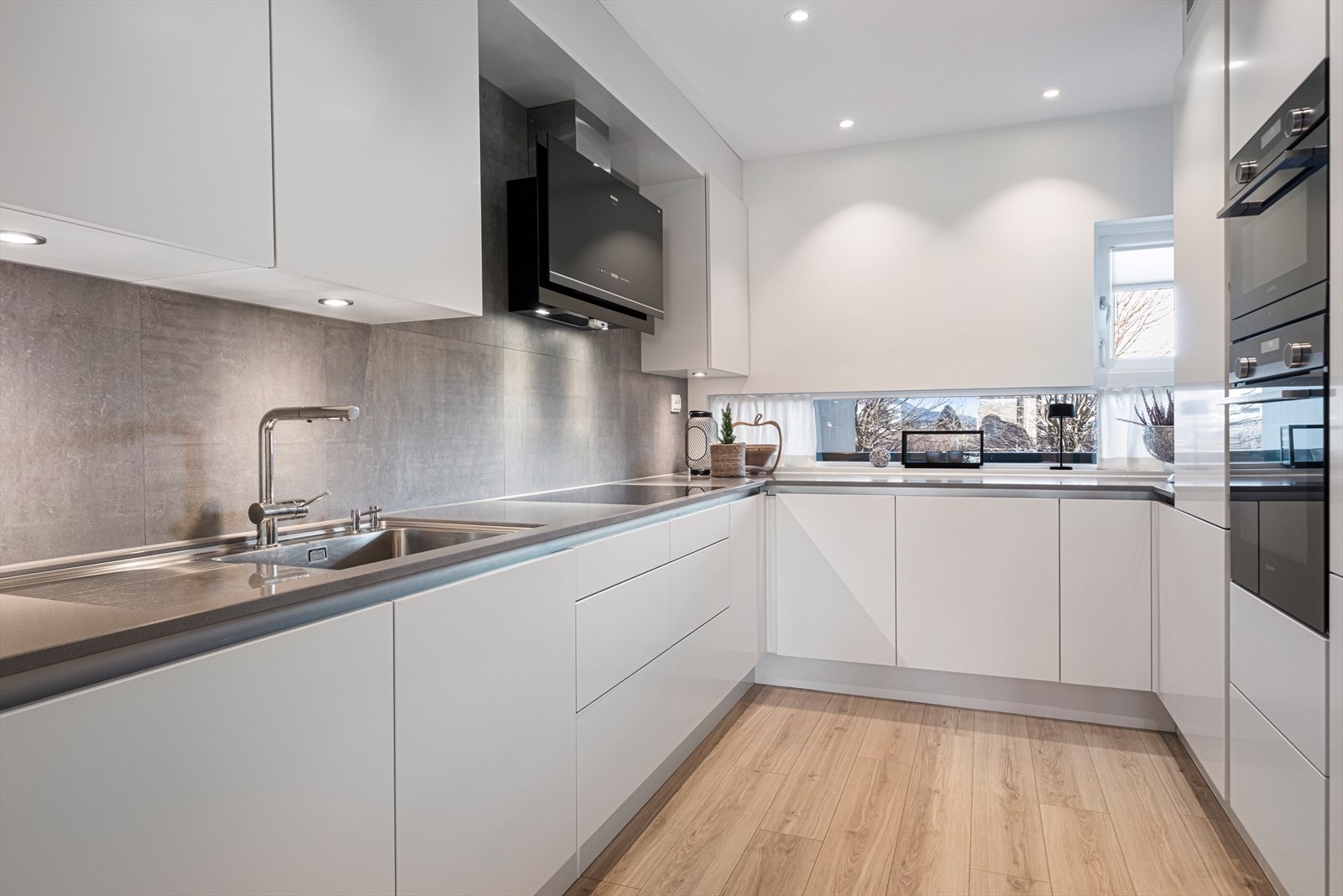 Kjøkkenet har en påkostet innredning fra HTH og her er benkeplater av stein Galleribilde