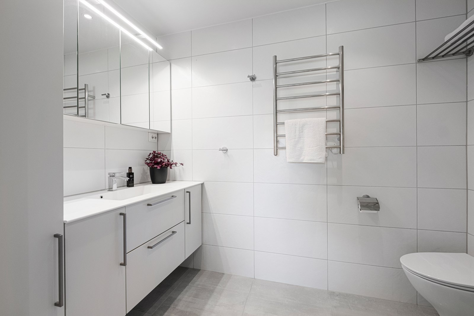 Romslig innredning m/servant - elektrisk håndkletørker er montert på vegg Galleribilde