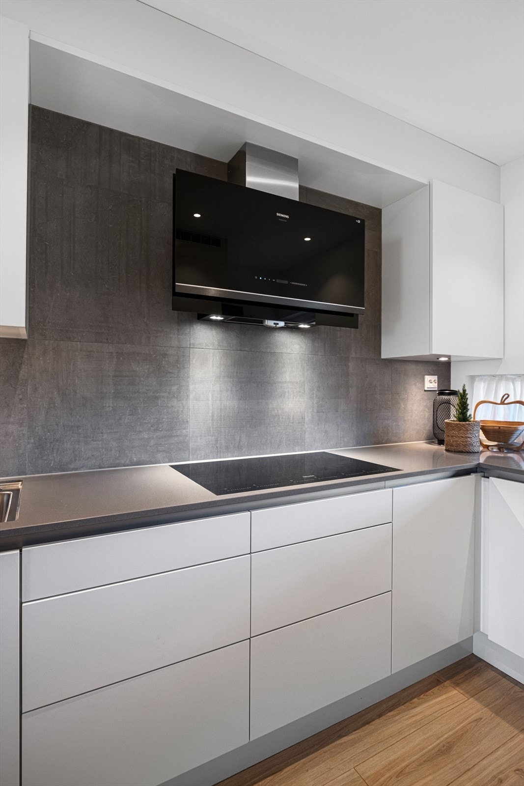 Her er fliser på vegg bak vask og platetopp Galleribilde