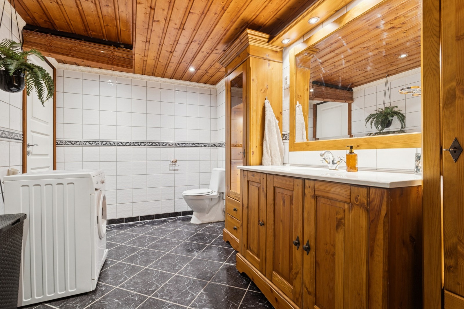 Badet i leiligheten er av god størrelse med trepanel i taket også flislaget vegger og gulv. Galleribilde