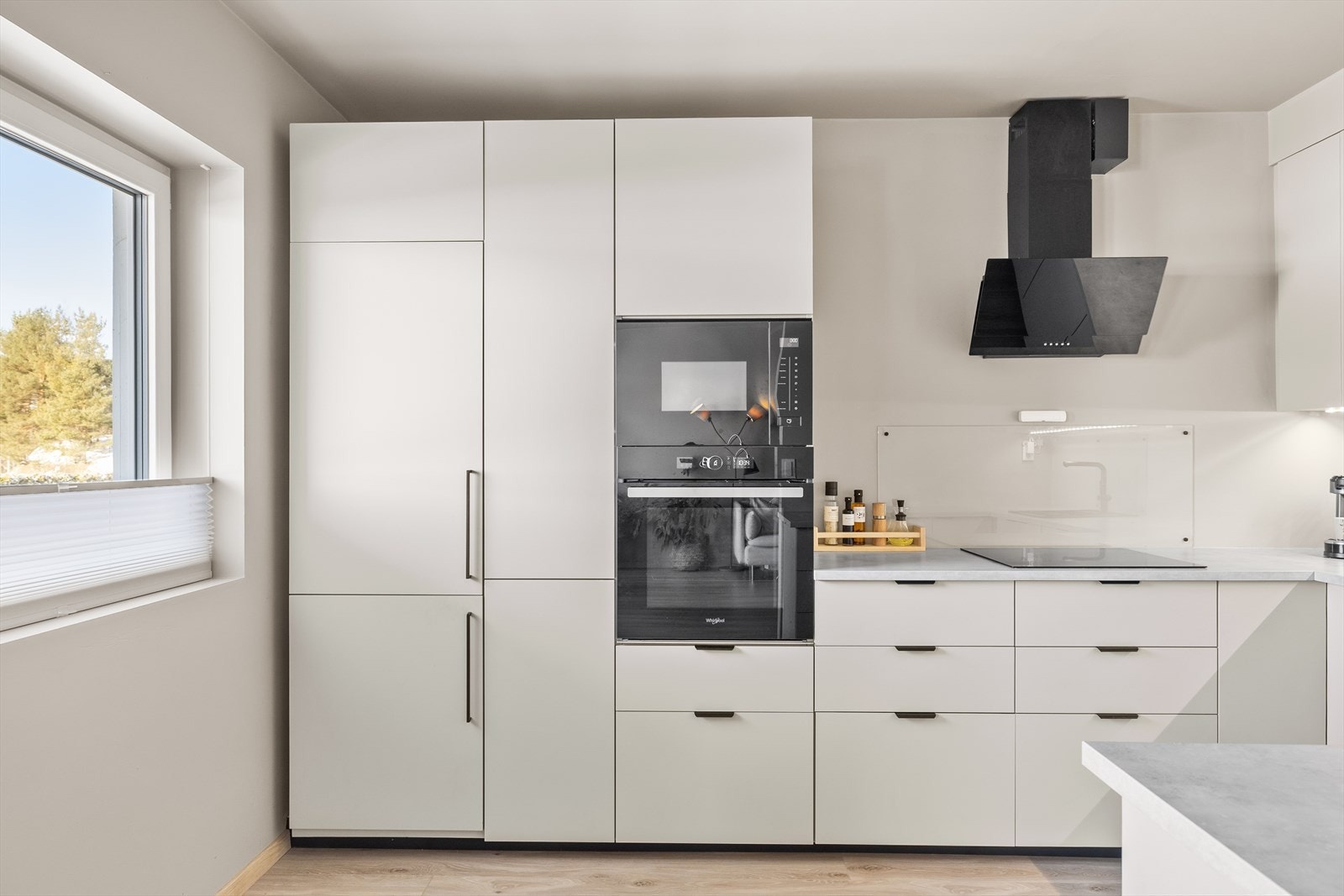 Stilrent kjøkken med glatte fronter og benkeplate i i høytrykkslaminat. Galleribilde