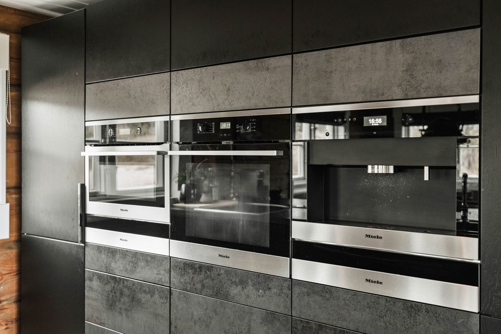 Integrerte Miele-hvitevarer og helhetlig uttrykk i mørk, moderne tone. Galleribilde