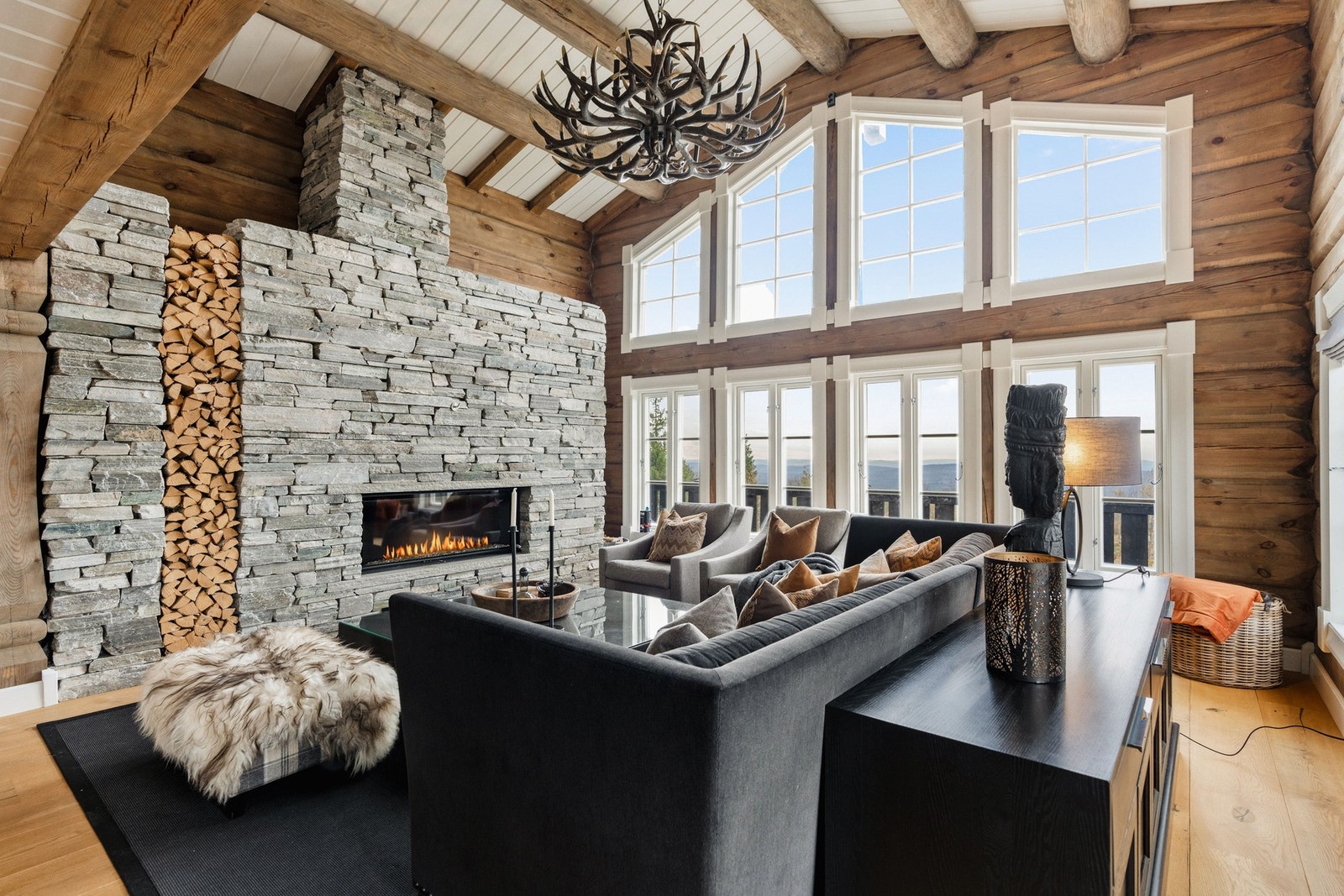 Fantastisk stue med himmelhøye vinduer og skiferkledd peis. Galleribilde