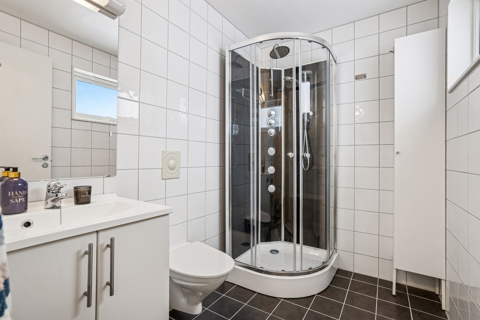 Flislagt bad med dusj og gode oppbevaringsløsninger. Galleribilde