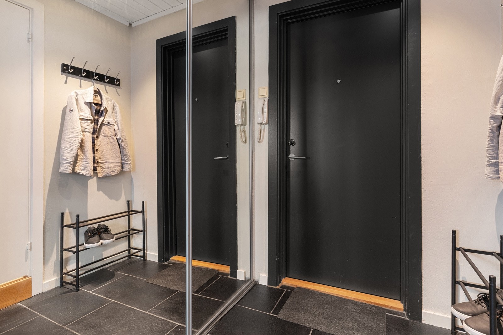 Praktisk entré med flislagt gulv og skyvedørsgarderobe som gir rikelig med oppbevaringsplass. Galleribilde