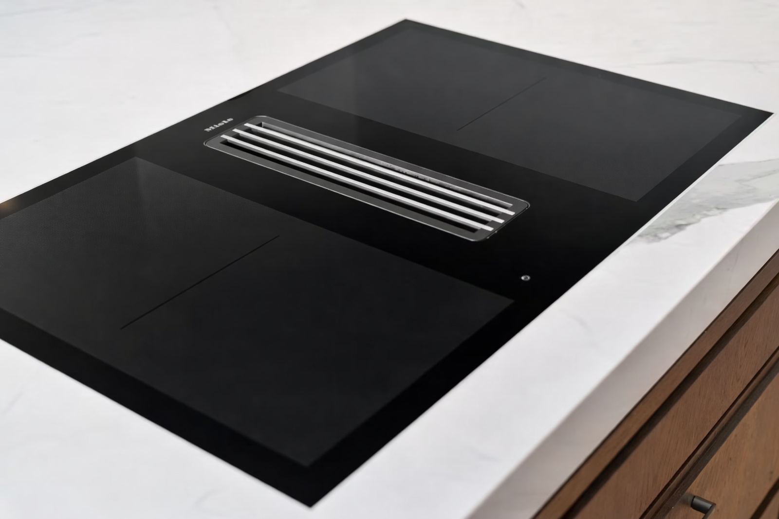 Induksjonstopp med integrert ventilator og kullfilterløsning, som gir et rent uttrykk og effektiv avtrekksfunksjon. Galleribilde