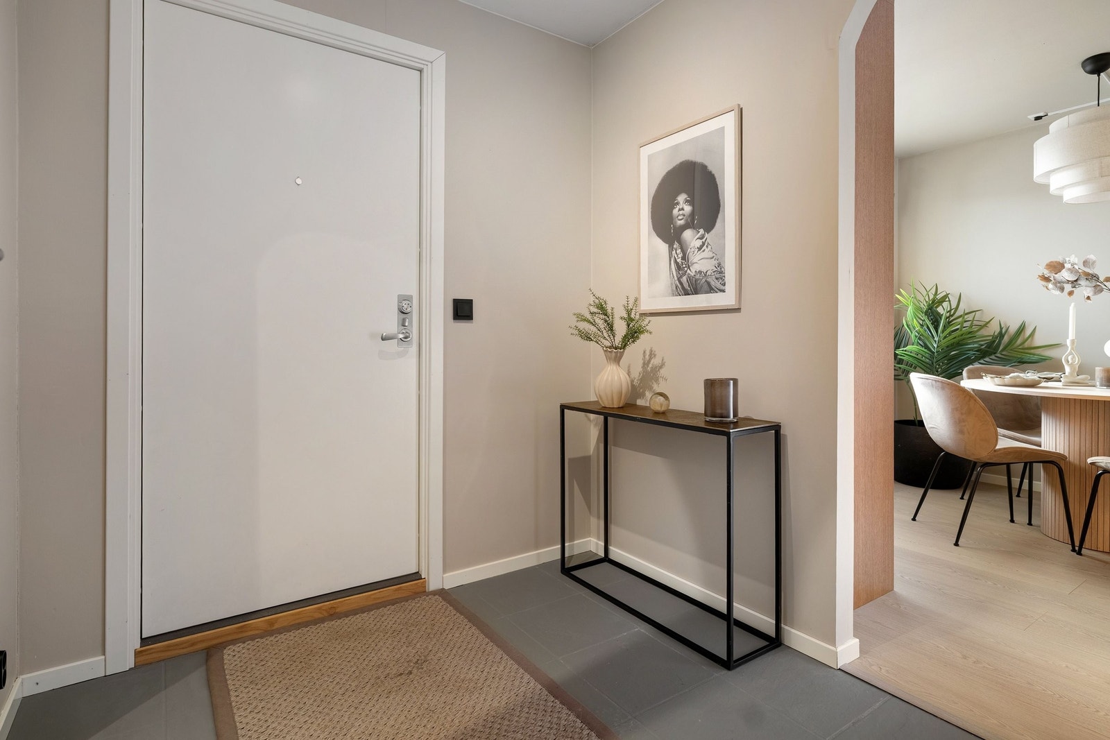 Inngangspartiet har malte fliser og buet åpning til kjøkken og spisegruppe Galleribilde