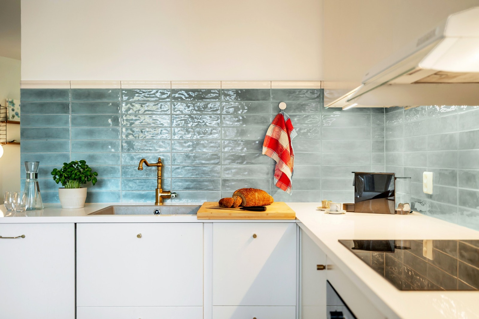 Det er montert hvit kjøkkeninnredning med over- og underskap, integrert belysning under overskap og Galleribilde