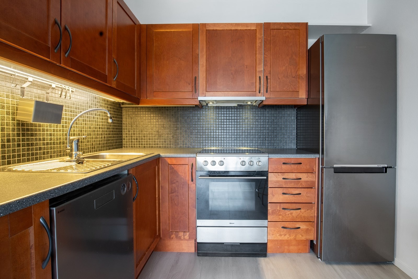 Kjøkkenet er utstyrt med kjøl-/fryseskap, oppvaskmaskin og komfyr som gir en komplett og bruksklar løsning. Galleribilde