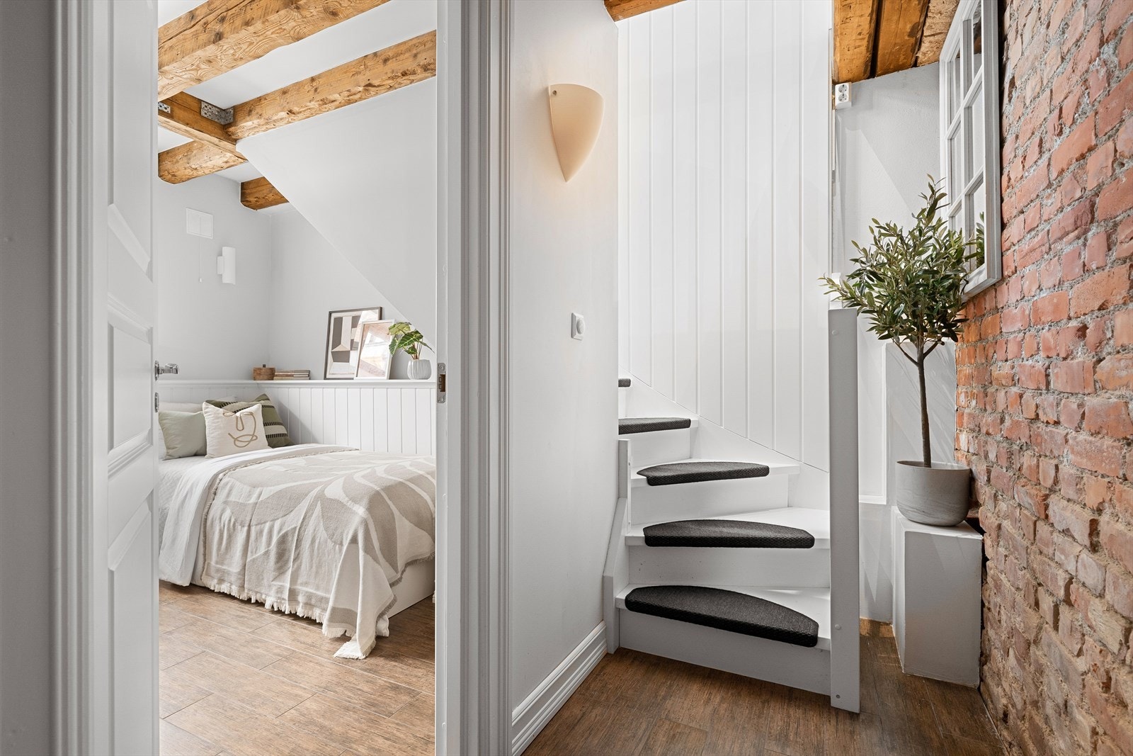 Vel nede i underetasjen kommer flere av leilighetens smakfulle detaljer til syne i form av klassiske takbjelker Galleribilde