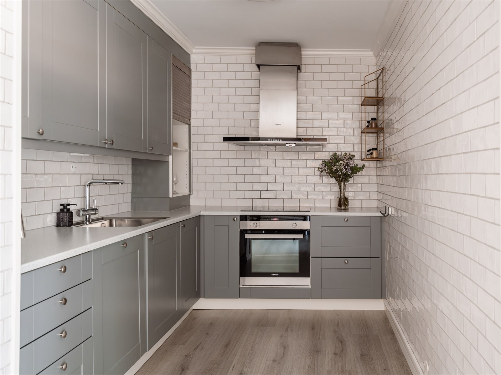 Kjøkkenet fra 2016 har en grå, glatt innredning fra Norema med integrerte hvitevarer. Galleribilde