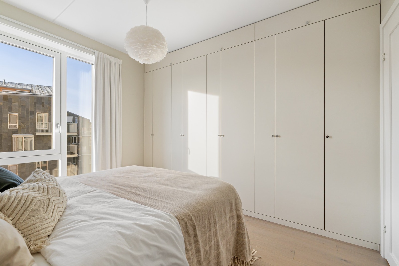 Plassbygd garderobeskap i samme fargetone som veggene, med en stilren og gjennomført utførelse. Galleribilde