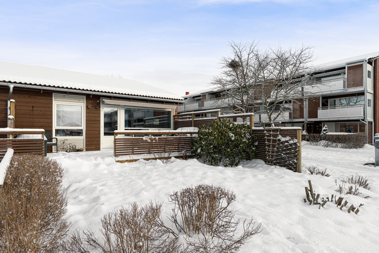 Fra stuen er det utgang til en frodig hage på sommerstid. Galleribilde