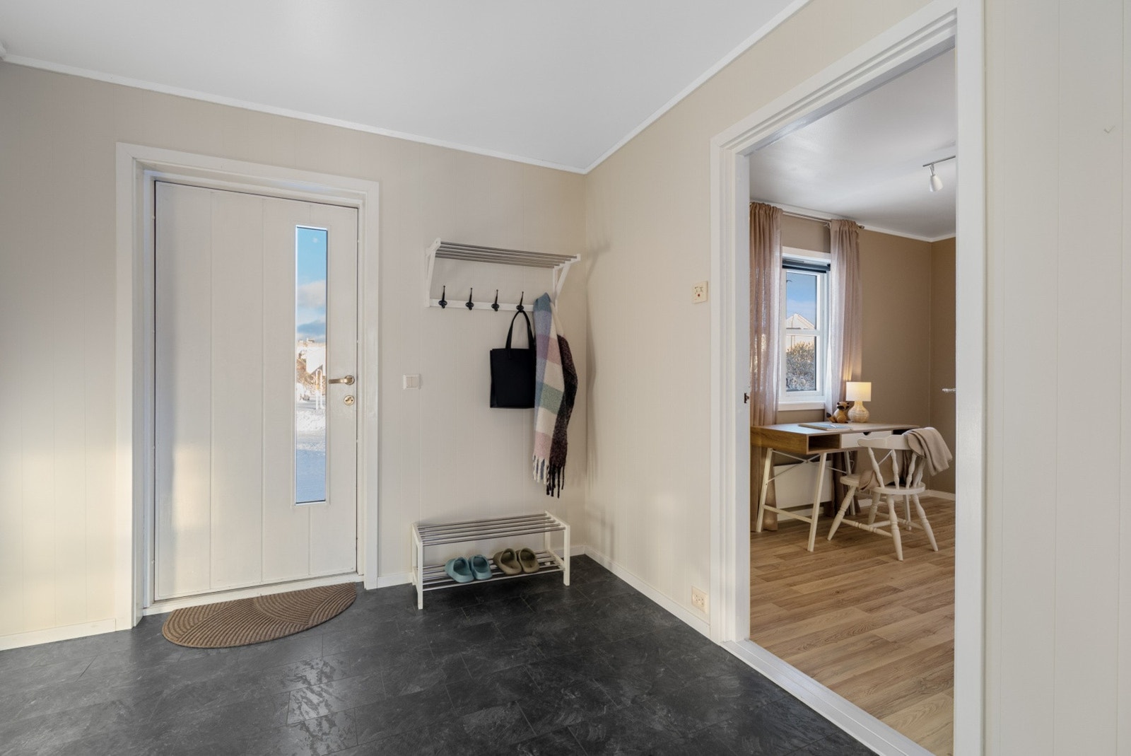 Rommet er praktisk utformet med plass til garderobeløsninger for yttertøy og sko, slik at du enkelt kan holde orden i hverdagen. Galleribilde