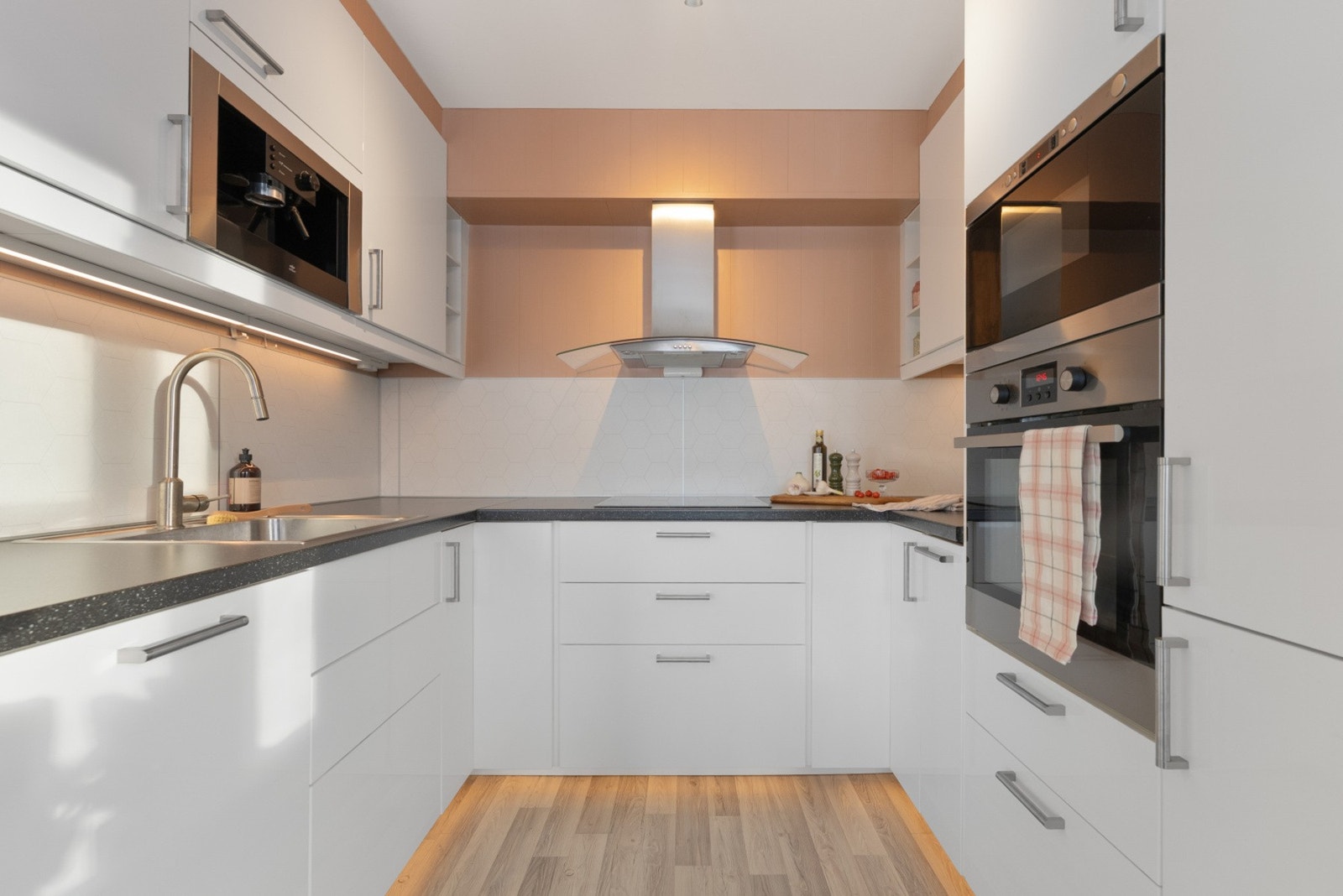 Kjøkkenet er smart integrert i den åpne løsningen, noe som gjør at den som lager mat kan være en del av det sosiale livet i stuen. Galleribilde