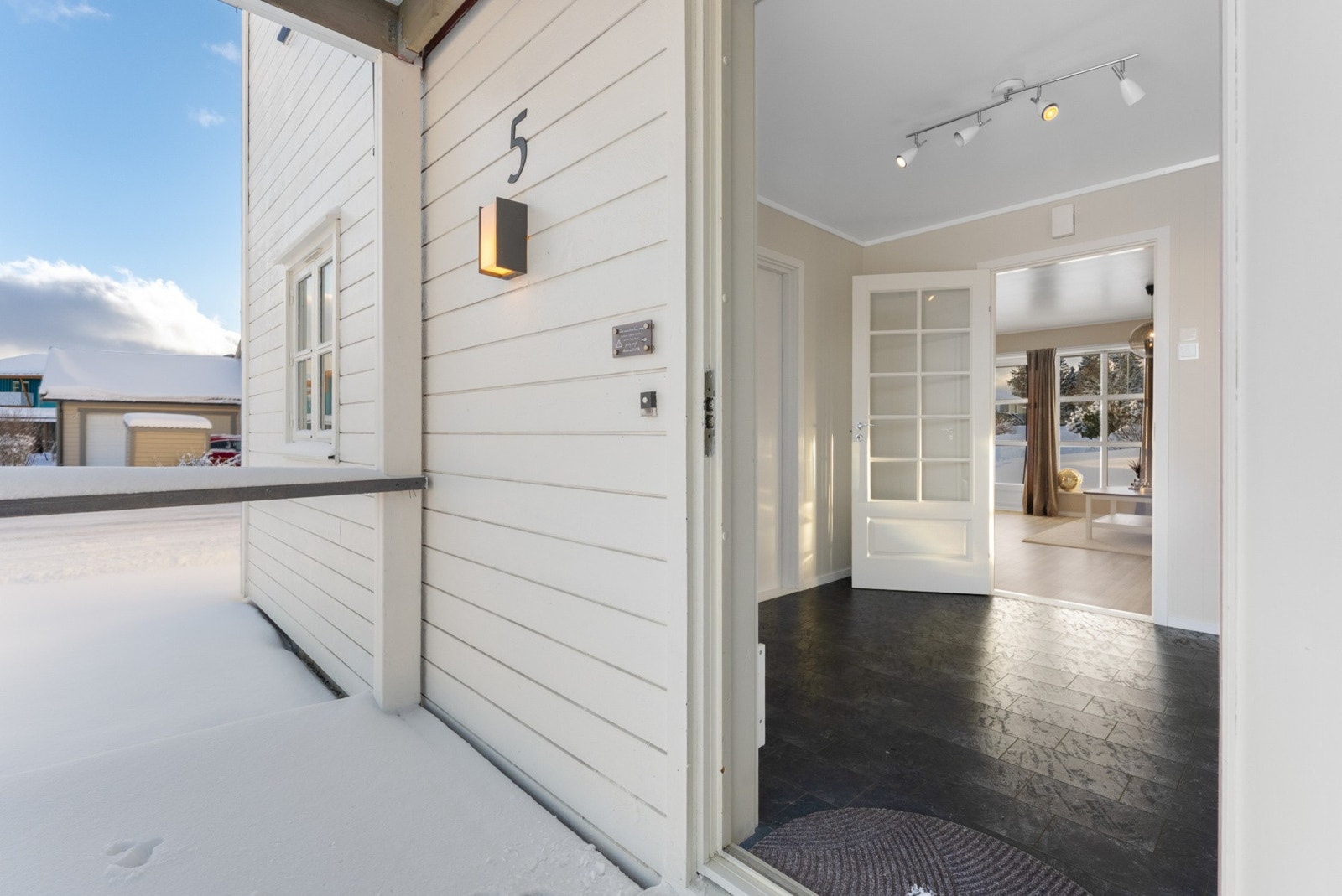 Overbygd inngangsparti som gir en lun og værbeskyttet adkomst til boligen. Galleribilde