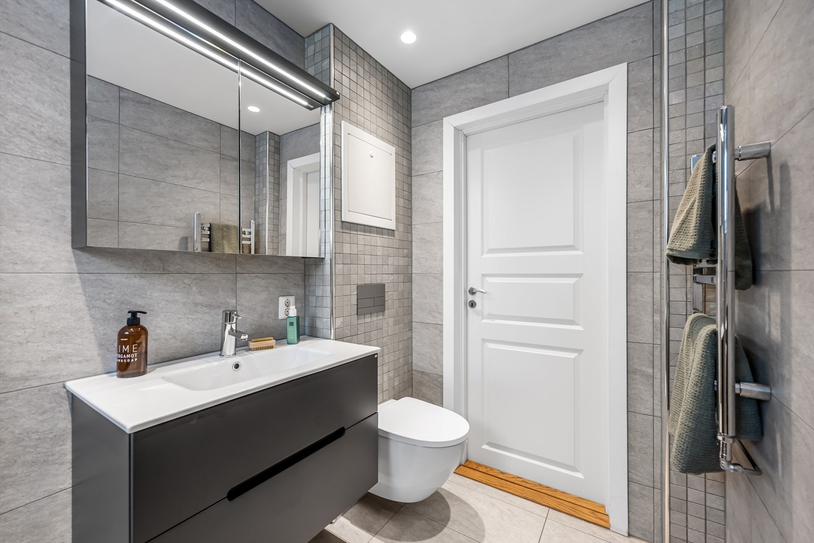 Praktisk innredning med servant i underskap og speilskap med belysning. Galleribilde