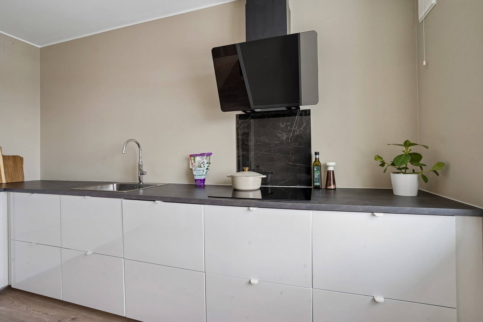 Kjøkkenet har en nyere, stilren vinkelinnredning med glatte høyglansfronter og laminatbenkeplate. Galleribilde