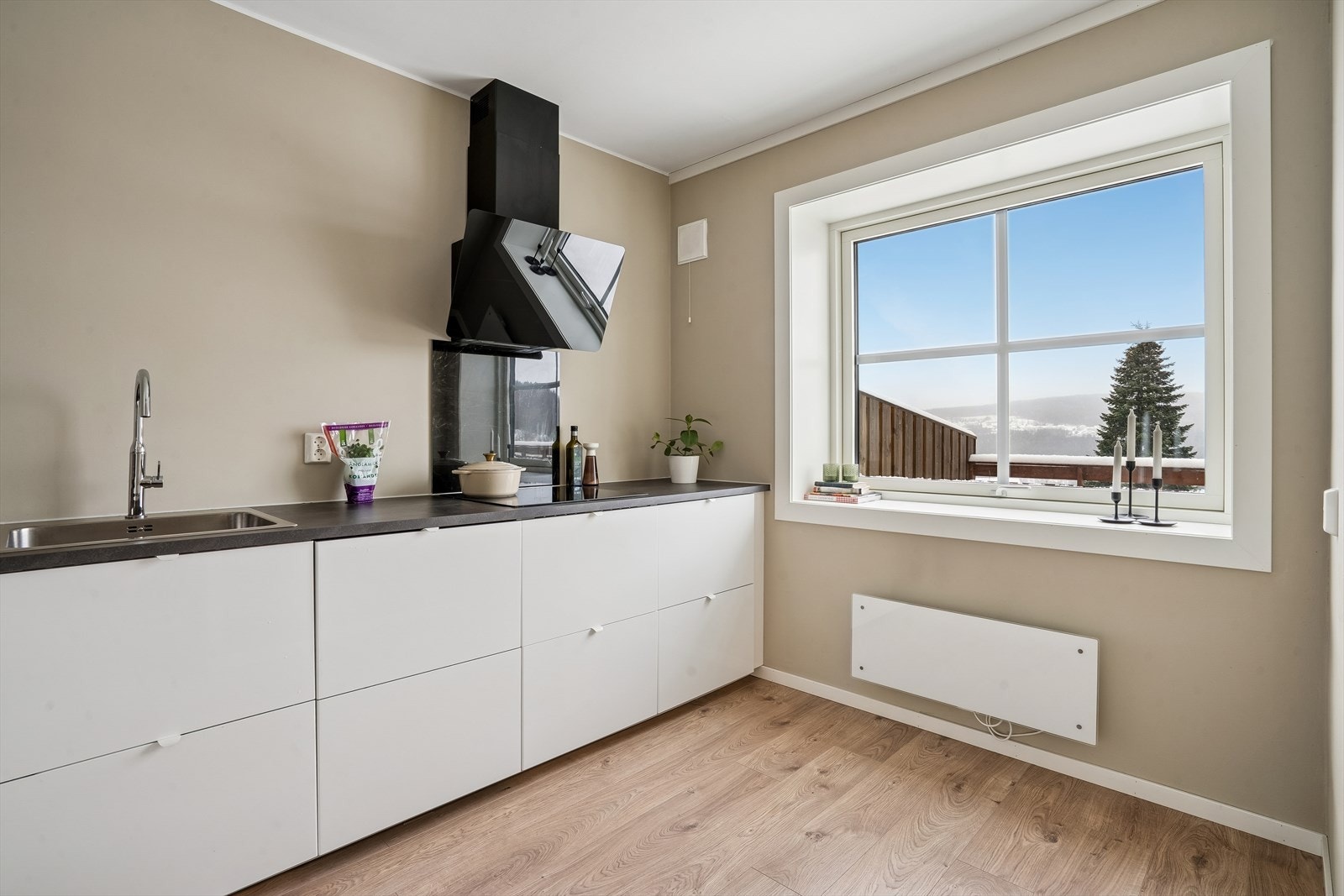 Ventilator med glassfront og en praktisk steinplate over koketoppen. Galleribilde