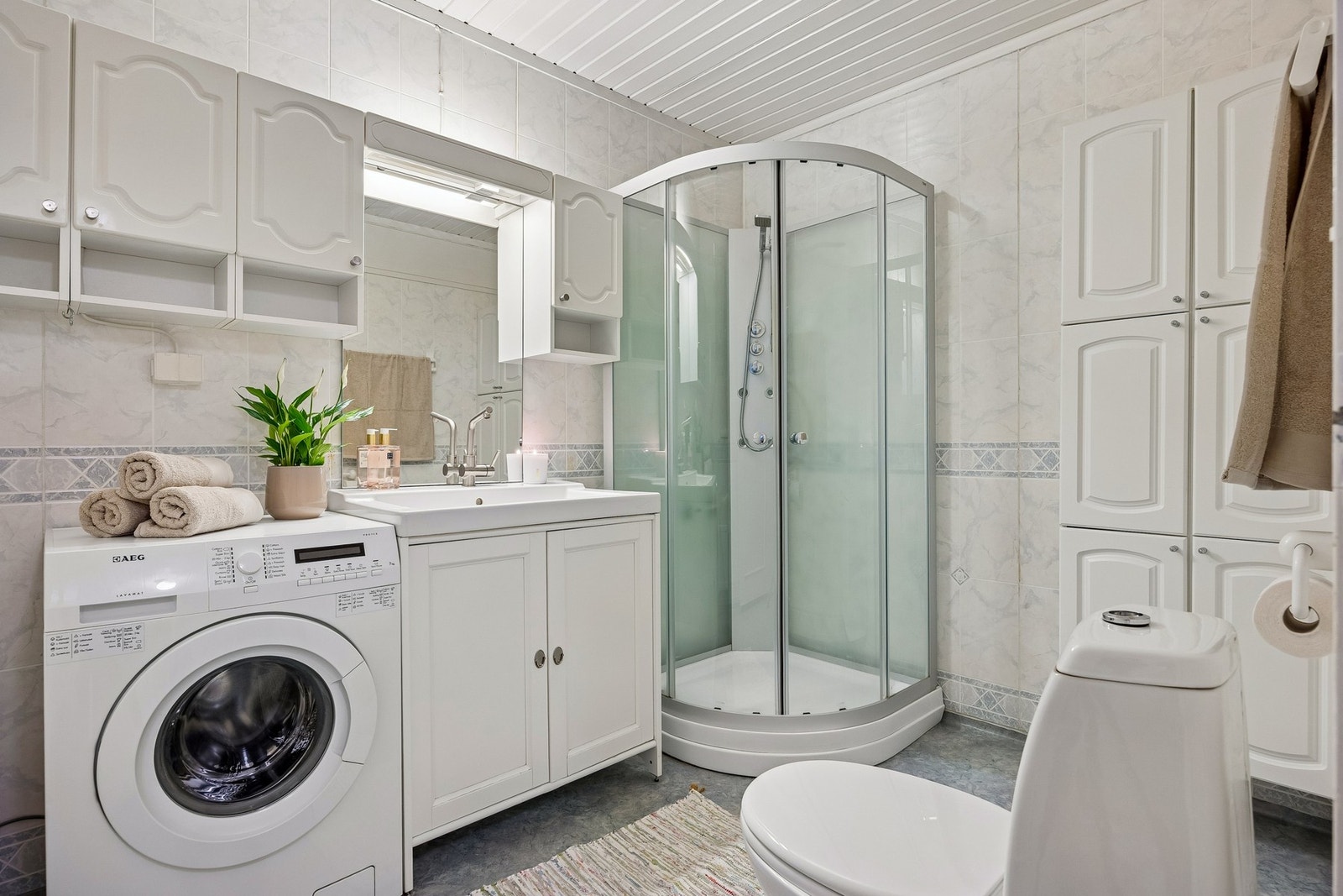 Badet har opplegg til vaskemaskin, nyere servantinnredning og dusjkabinett. Galleribilde
