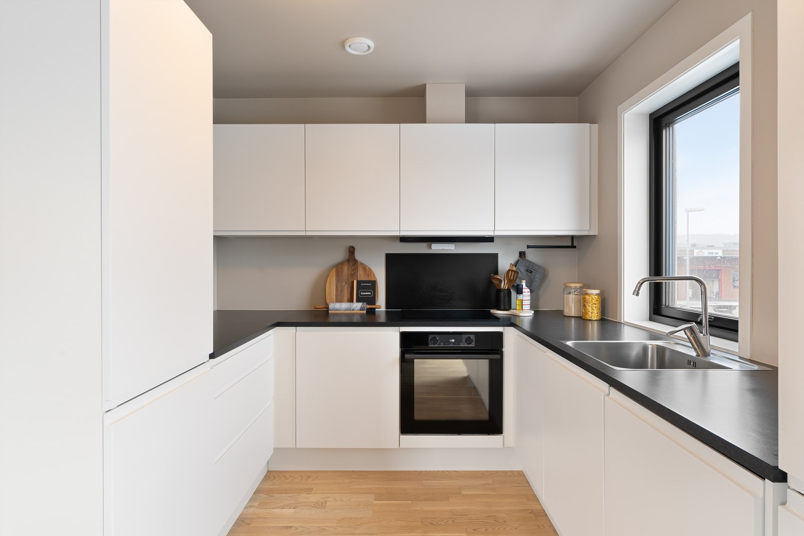 Lyst kjøkken med integrerte hvitevarer Galleribilde