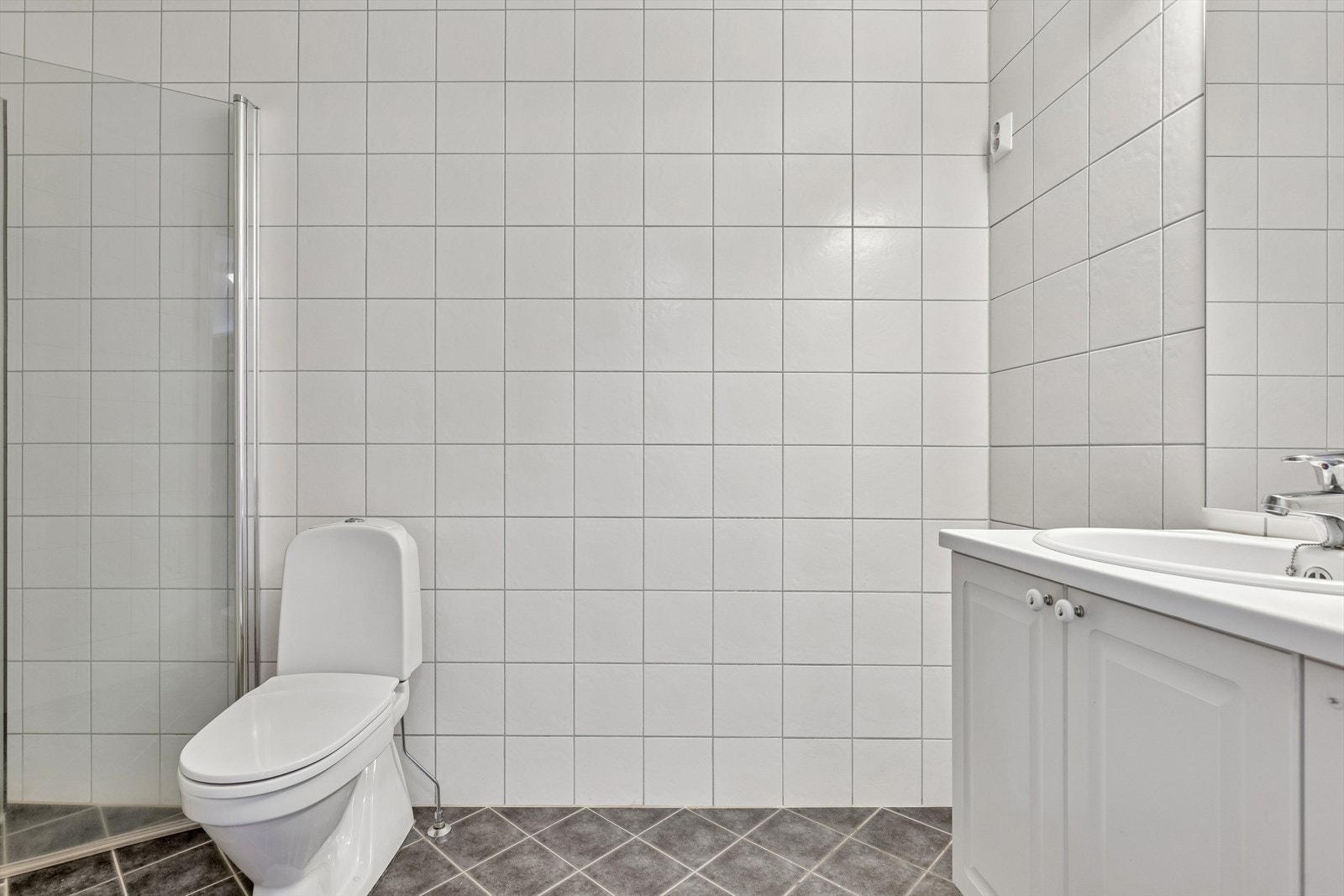 Badet er utstyrt med vegghengt servantskap, speil og gulvstående toalett. Galleribilde