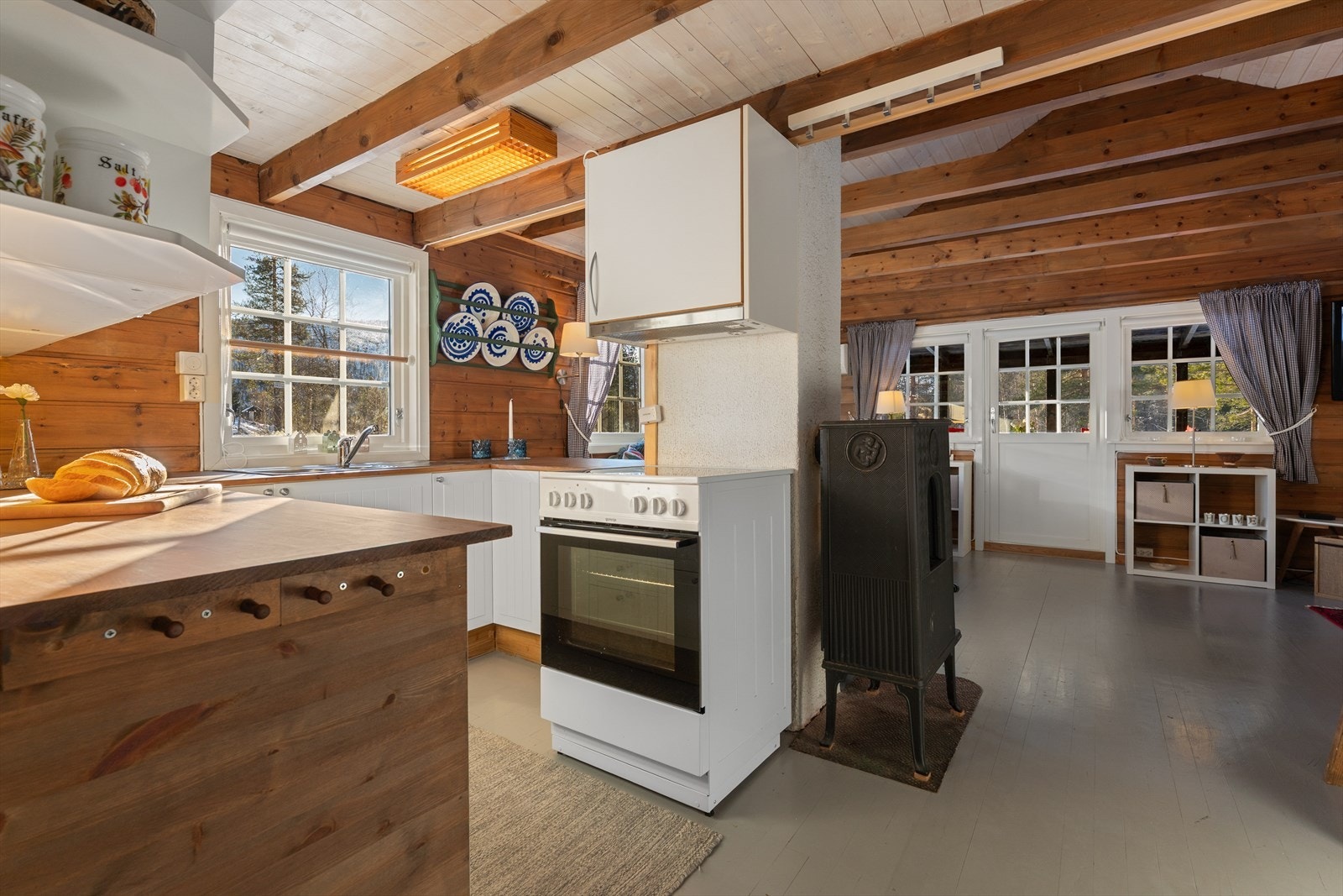 Kjøkkenet har innredning med glatte fronter og benkeplate i laminat Galleribilde