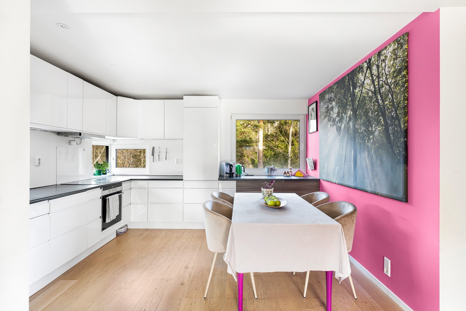 Det innbydende kjøkkenet har en gjennomtenkt og praktisk innredning med glatte fronter og en stilfull laminat benkeplate. Galleribilde