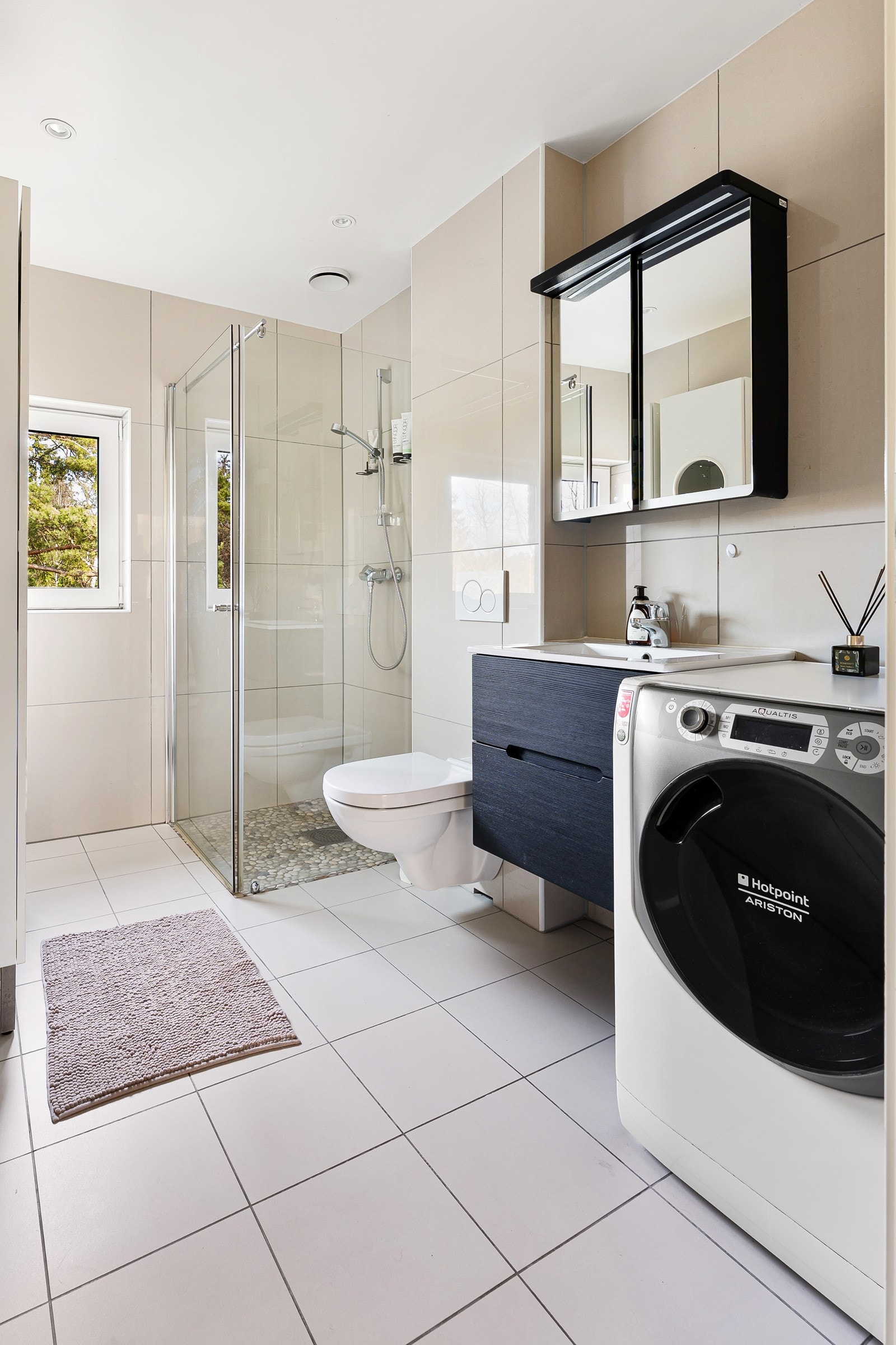 Badet på denne etasjen har et moderne design med fliser på både vegger og gulv, samt malte plater i taket. Galleribilde