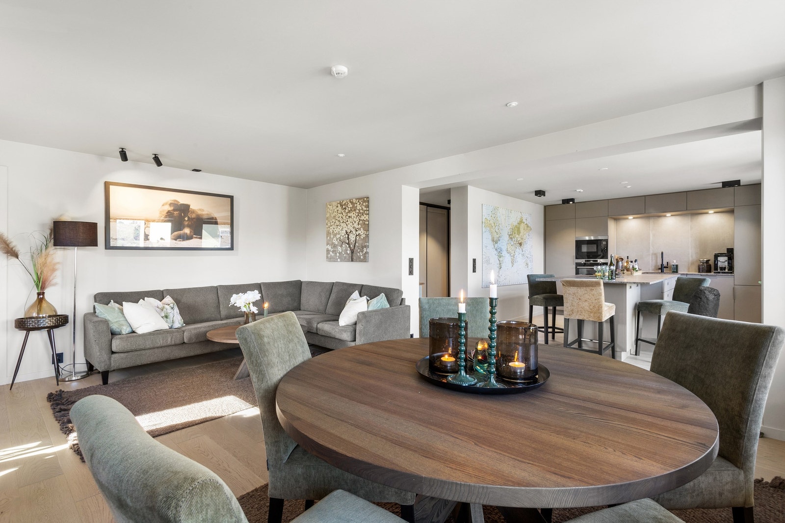 Åpen kjøkken- og stueløsning med sofaområde samt spiseplass Galleribilde