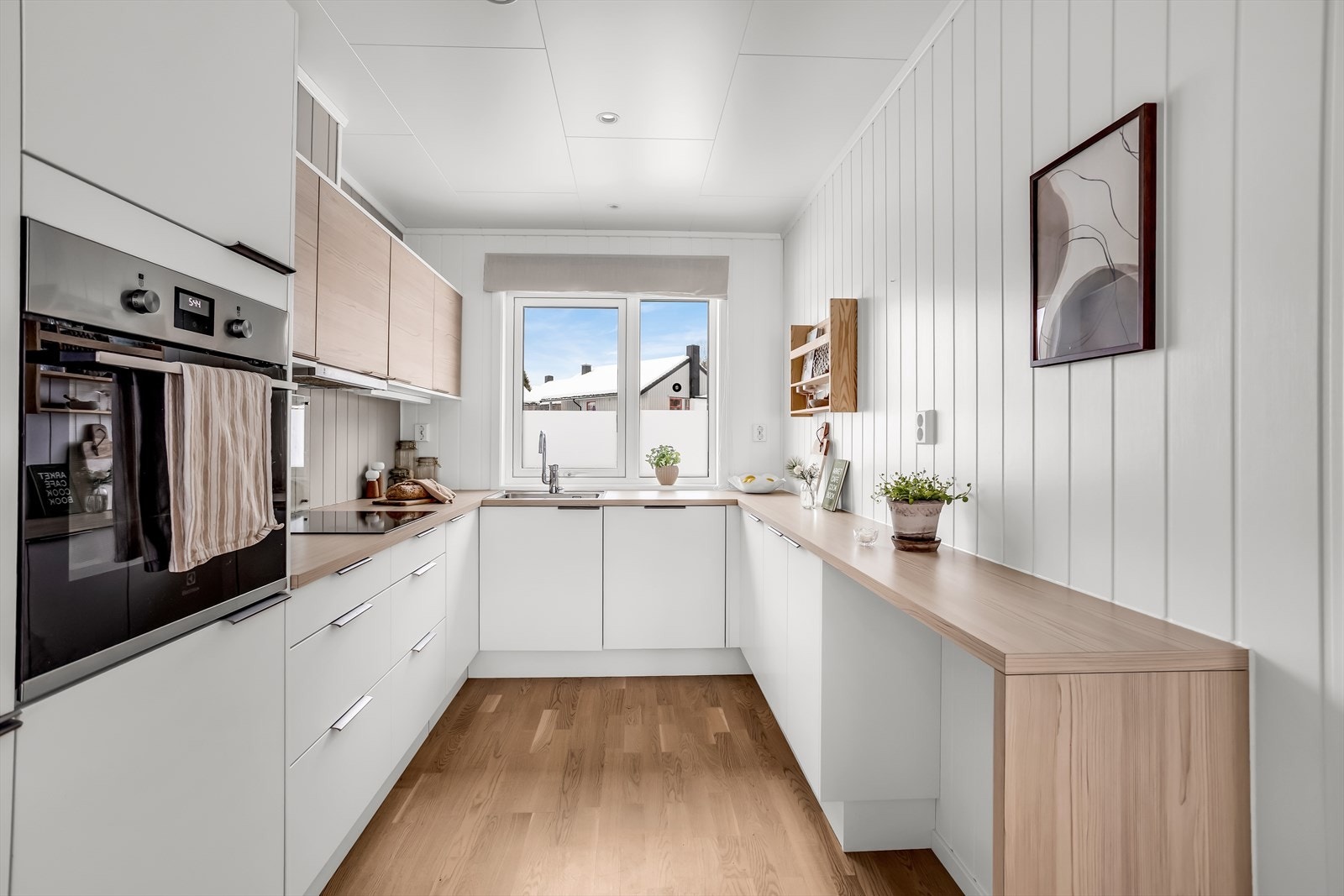 Moderne kjøkken med glatte, hvite fronter og laminat benkeplate. Galleribilde