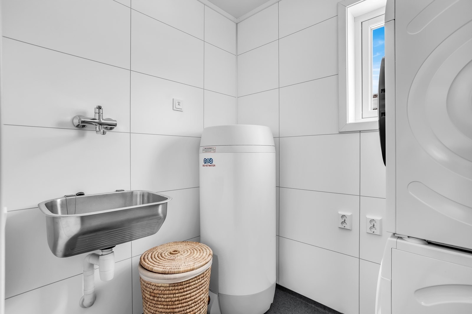 Separat vaskerom med gulvbelegg, utslagsvask, opplegg for vaskemaskin og varmtvannstank fra 2021. Galleribilde