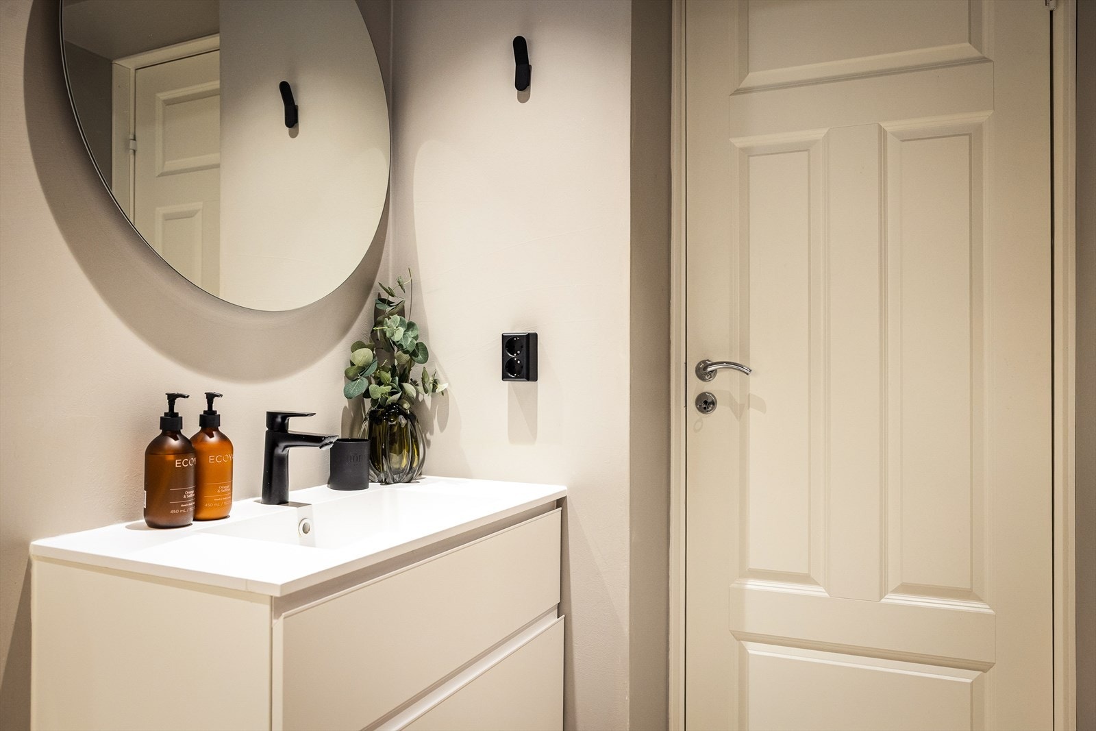 Innredning og garnityr på badet består av veggmontert toalett (Laufen Riva dusjtoalett), dusjhjørne med innfellbare glassdører og baderomsinnredning med skuffer, servant med ettgrepsblandebatteri og speil. Galleribilde