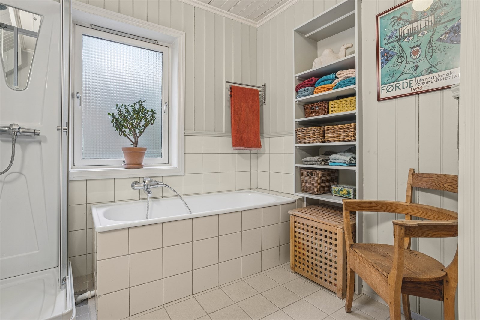 Badet er innredet med toalett, servant med tilhørende innredning, speil og belysning, samt både dusjkabinett og innfliset badekar. Det er mekanisk avtrekk i rommet, mens tilluft tilføres via spalte under døren. Galleribilde