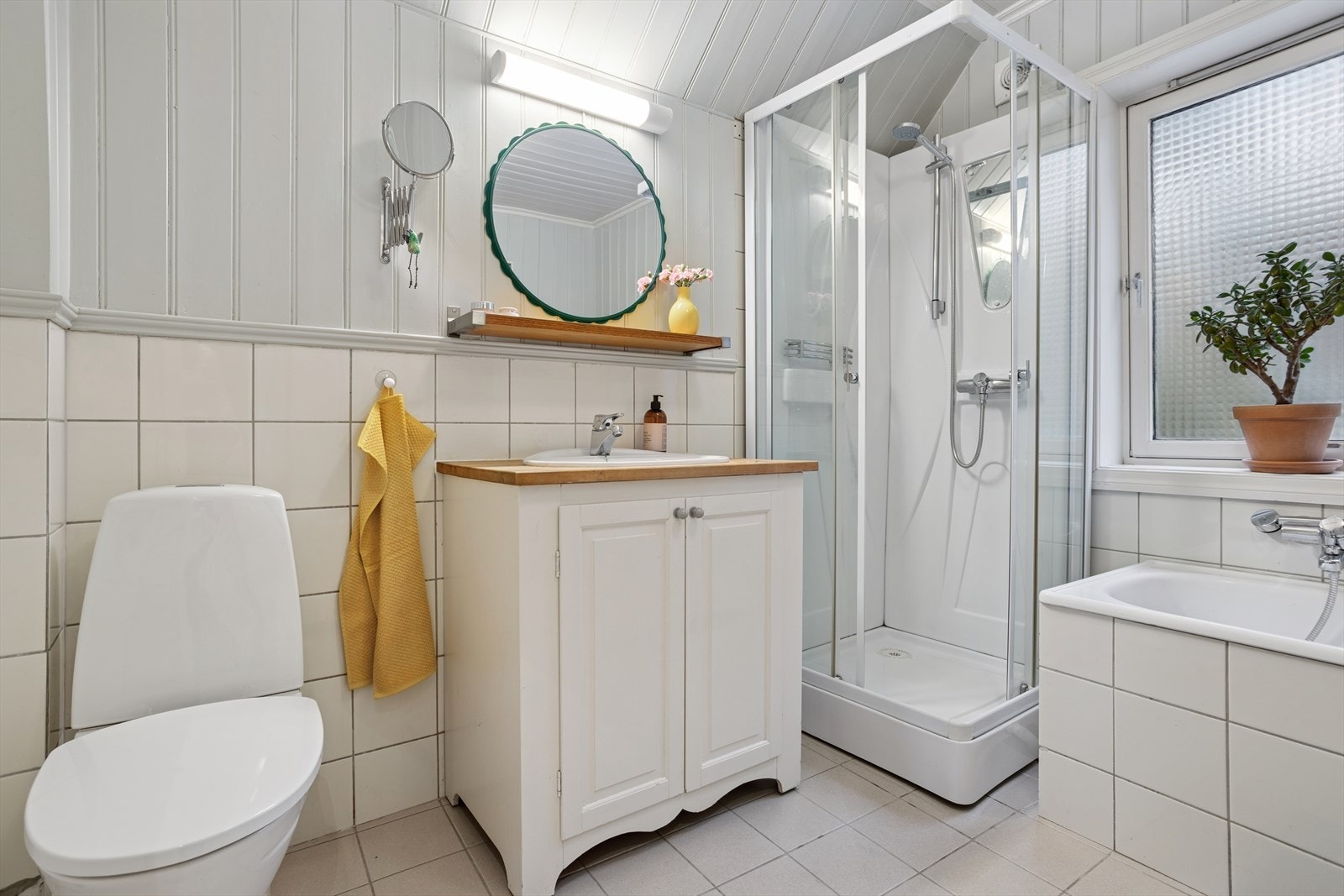 I boligens andre etasje ligger et eldre men funksjonelt baderom. Rommet har et klassisk uttrykk med flislagt gulv og vegger som består av en kombinasjon av fliser og panel, noe som gir badet et tidstypisk preg. Galleribilde