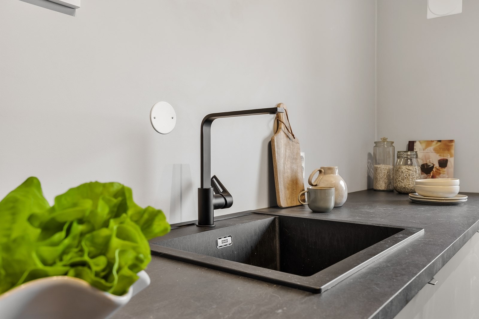 Ettgreps kjøkkenkran og praktiske stikkontakter over benken gjør matlagingen enkel. Galleribilde