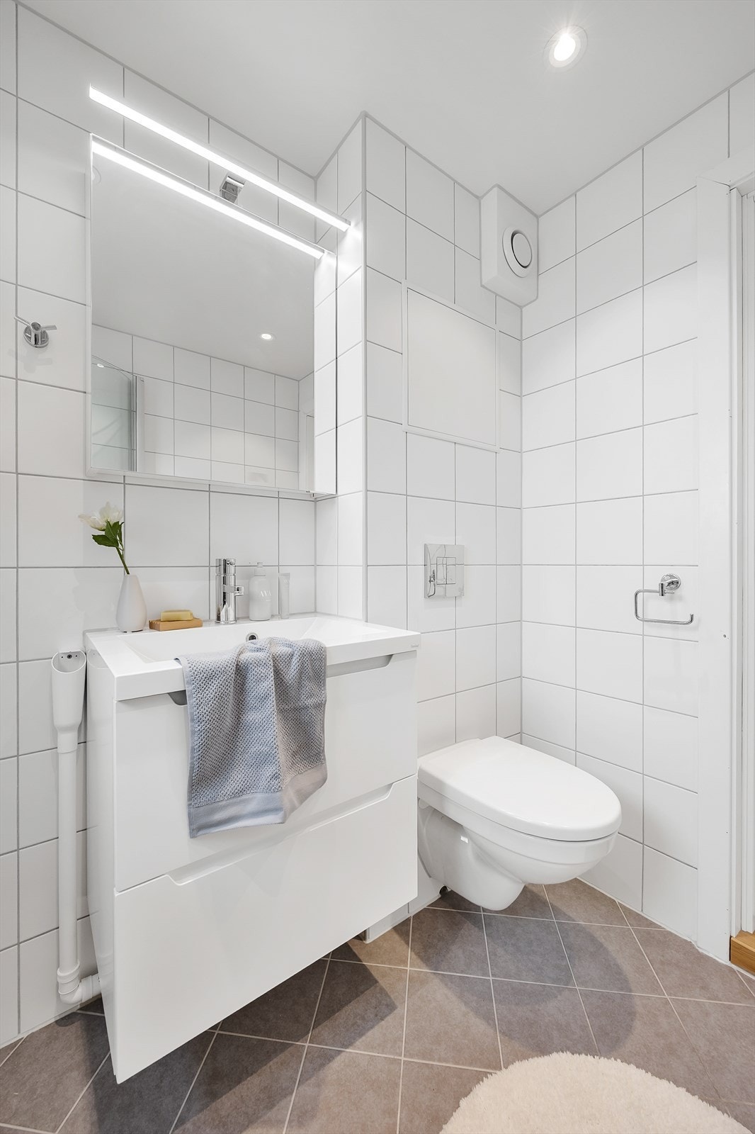 Her er det vegghengt toalett, servant med skuffer og speilskap med lys og stikkontakt. Galleribilde