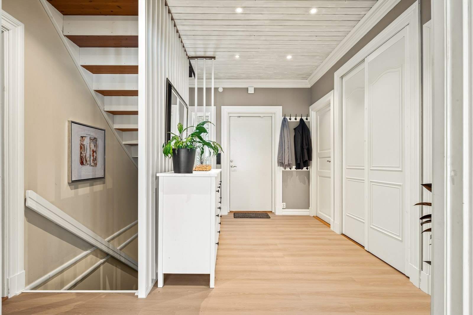 Lys entré ønsker velkommen inn. Praktisk skyvedørsgarderobe for oppbevaring av yttertøy. Galleribilde