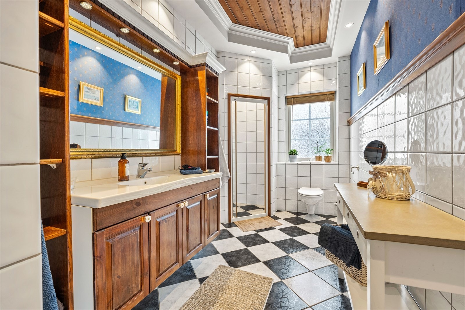 Badet i 1. etasje har flislagt gulv. Veggene er i kombinasjon av flis og tapet. Vannbåren gulvvarme - noe som gir ekstra komfort. Galleribilde