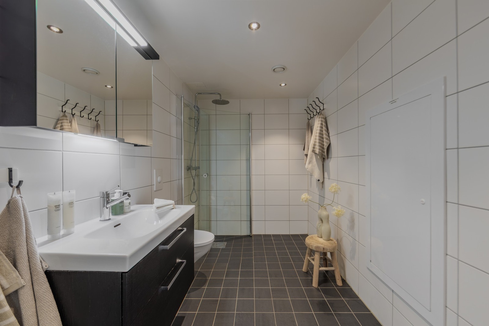 Fra entreen er det adkomst til et stort og luftig bad med tidløs innredning. Det er behagelig gulvvarme samt opplegg for egen vaskemaskin. Galleribilde